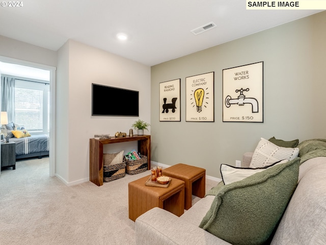 carpeted living area featuring visible vents and baseboards