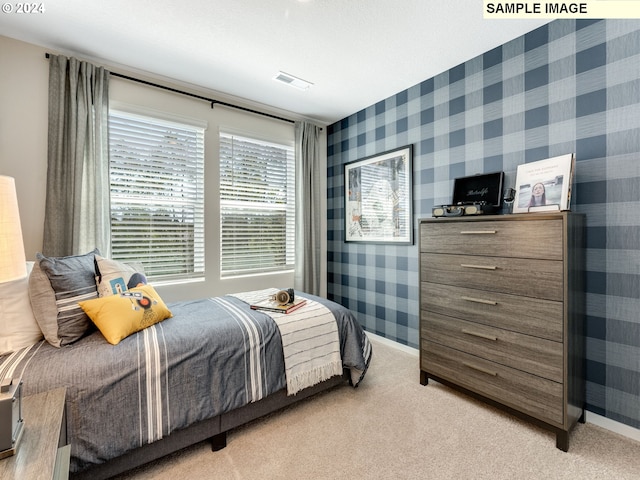 bedroom with light carpet, wallpapered walls, baseboards, and visible vents