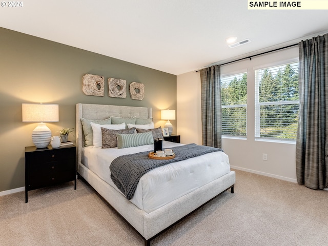 bedroom with visible vents, light carpet, and baseboards