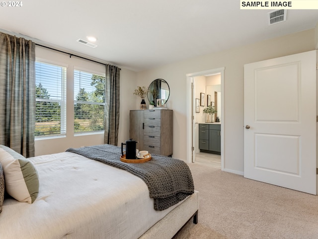 bedroom with light carpet, baseboards, visible vents, and connected bathroom