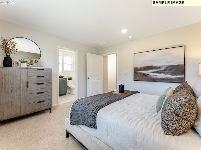 bedroom with ensuite bath and light colored carpet