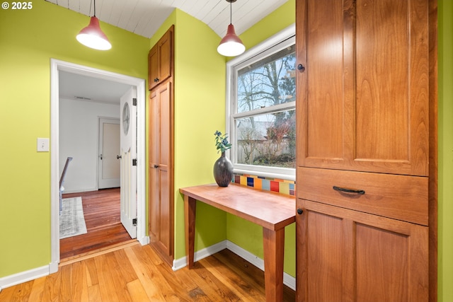 hallway featuring baseboards and light wood finished floors