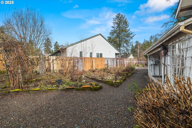 view of side of home with a fenced backyard and a vegetable garden