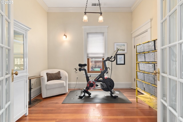 exercise area with visible vents, french doors, crown molding, and wood finished floors