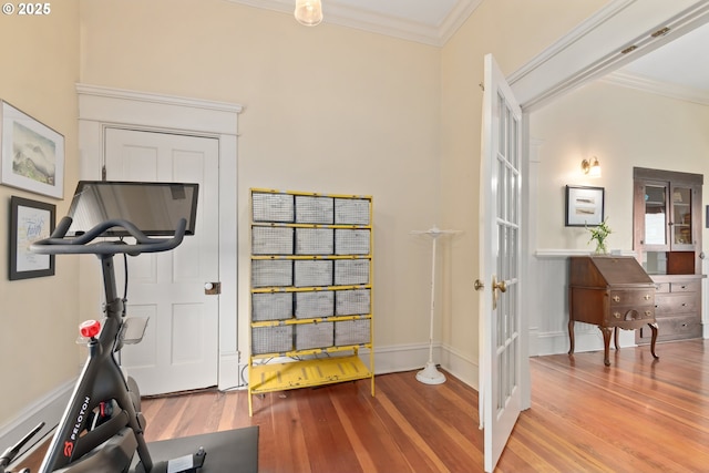 exercise area with crown molding, wood finished floors, baseboards, and french doors