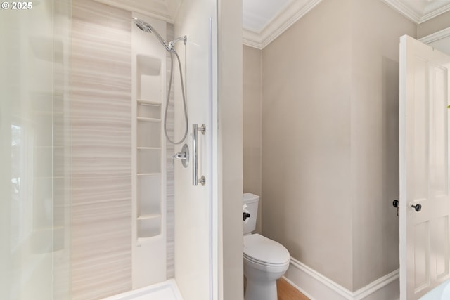 bathroom featuring baseboards, toilet, ornamental molding, and a walk in shower