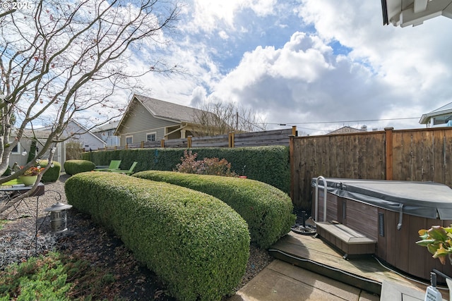 view of yard featuring fence and a hot tub