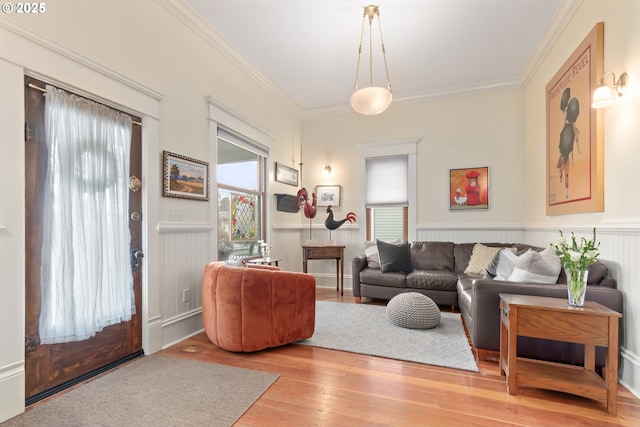 living room featuring a wainscoted wall, crown molding, and hardwood / wood-style flooring