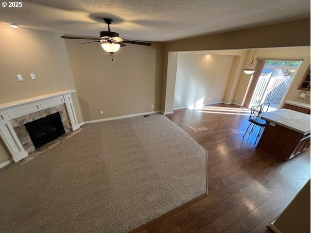 19941 Capital Ct, Oregon City, OR 97045 - unfurnished living room featuring ceiling fan, a textured ceiling, a fireplace, and wood finished floors