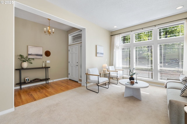 carpeted living area with a chandelier, baseboards, and recessed lighting