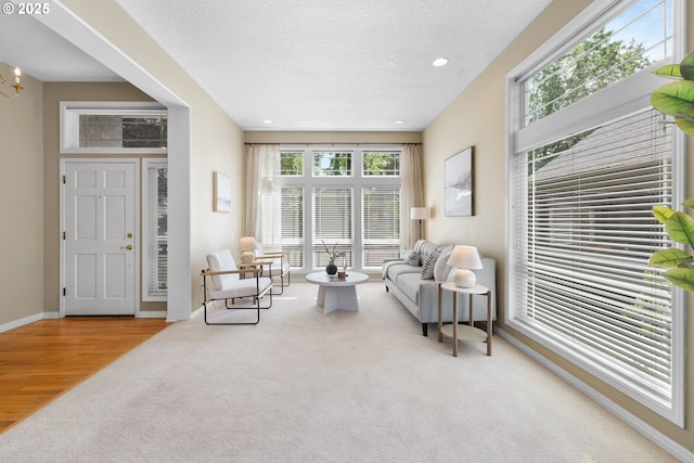 sitting room with carpet, baseboards, a textured ceiling, recessed lighting, and a chandelier