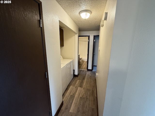 hallway featuring washer and clothes dryer, dark wood-type flooring, and a textured ceiling