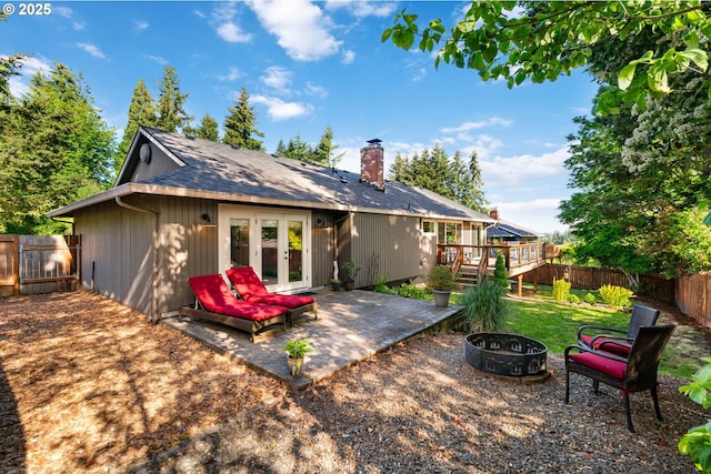 7780 Blinkhorn Way, Gladstone, OR 97027 - back of house featuring french doors, a fenced backyard, a fire pit, a chimney, and a deck