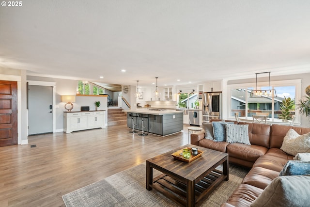 7780 Blinkhorn Way, Gladstone, OR 97027 - living room featuring stairway, healthy amount of natural light, light wood finished floors, recessed lighting, and a chandelier