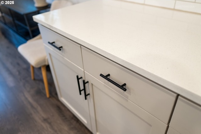 room details featuring dark hardwood / wood-style floors and white cabinets