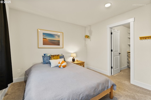 carpeted bedroom with a walk in closet