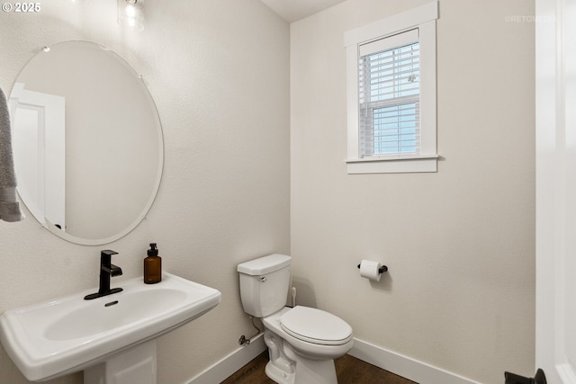 bathroom featuring hardwood / wood-style flooring, toilet, and sink