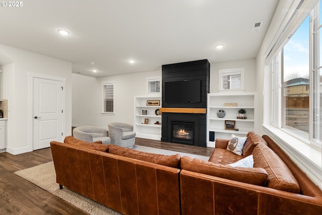 living room with dark hardwood / wood-style flooring and a fireplace