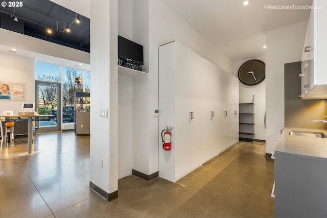 hallway featuring a high ceiling and sink