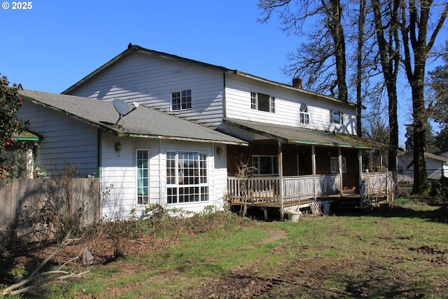 rear view of house featuring a yard