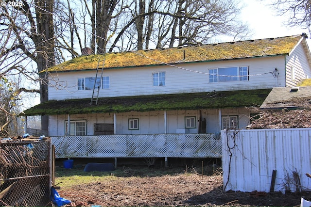 back of house featuring fence and a porch