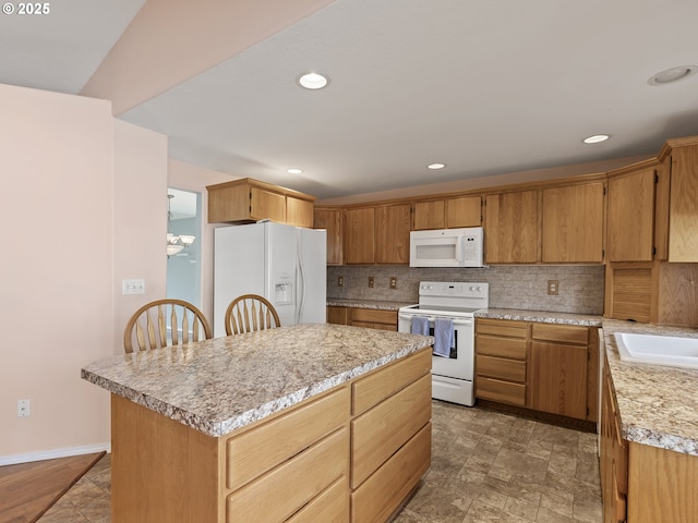 kitchen featuring a sink, tasteful backsplash, a kitchen island, white appliances, and light countertops