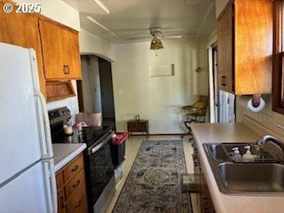 14031 SE Rhone St, Portland, OR 97236 - kitchen featuring electric range oven, freestanding refrigerator, a sink, brown cabinets, and arched walkways