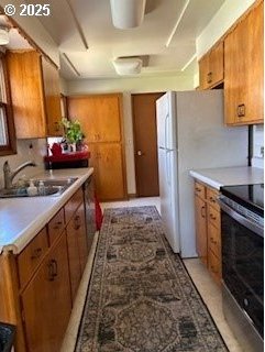 14031 SE Rhone St, Portland, OR 97236 - kitchen featuring stainless steel range with electric stovetop, a sink, brown cabinetry, and light countertops