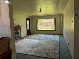 14031 SE Rhone St, Portland, OR 97236 - unfurnished living room with carpet, a glass covered fireplace, and a textured ceiling