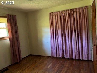 14031 SE Rhone St, Portland, OR 97236 - spare room featuring dark wood-type flooring and a textured ceiling