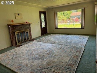 14031 SE Rhone St, Portland, OR 97236 - unfurnished living room with carpet flooring, plenty of natural light, and a fireplace