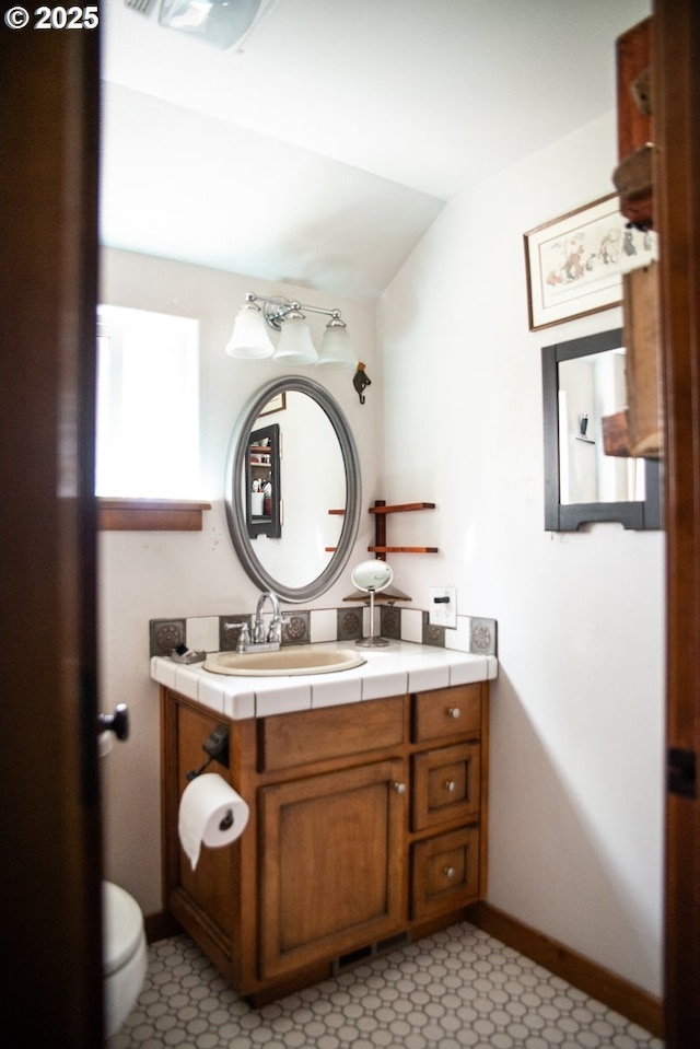 62725 Eagle Rd, Bend, OR 97701 - half bathroom with vanity, baseboards, toilet, and lofted ceiling