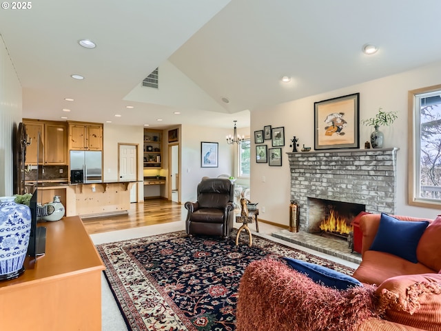 living area with lofted ceiling, recessed lighting, plenty of natural light, and a brick fireplace