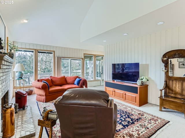 living room featuring light carpet, a fireplace, high vaulted ceiling, and a wealth of natural light