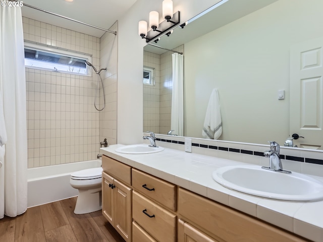 full bath with wood finished floors, shower / bath combo, a sink, and toilet