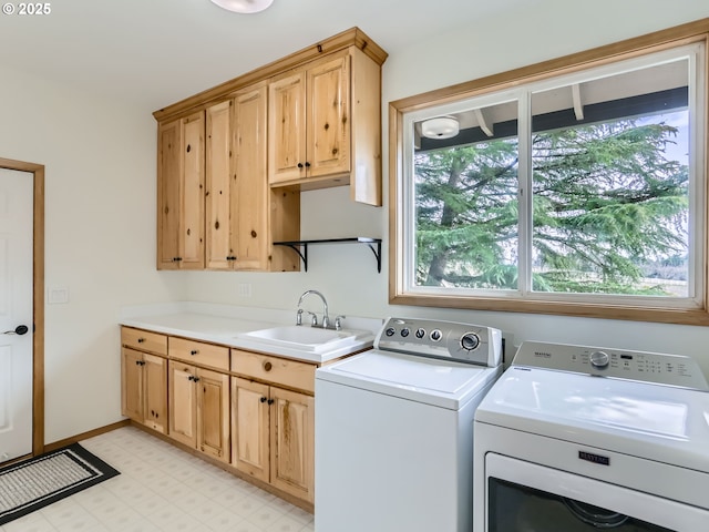 laundry area with light floors, cabinet space, a sink, washer and dryer, and baseboards