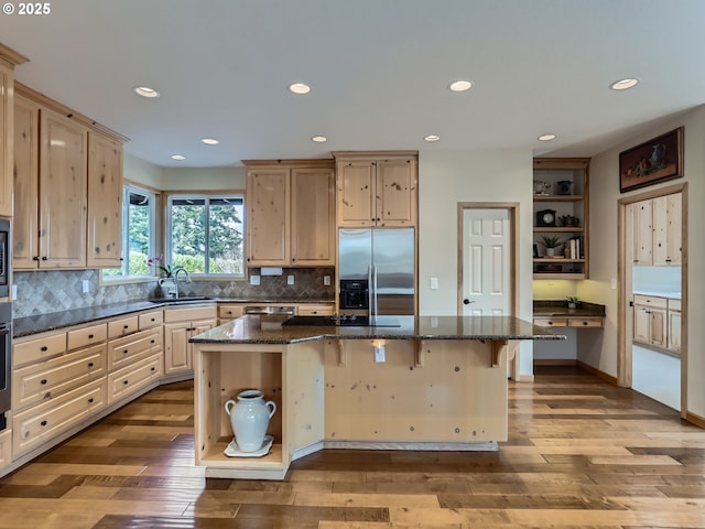 kitchen featuring light brown cabinets, stainless steel appliances, open shelves, and a kitchen island