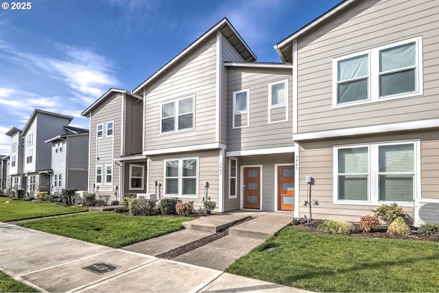 view of property with a front yard, ac unit, and a residential view