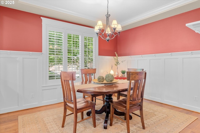 2121 Ostman Rd, West Linn, OR 97068 - dining area featuring a decorative wall, crown molding, wainscoting, a chandelier, and light wood-style flooring