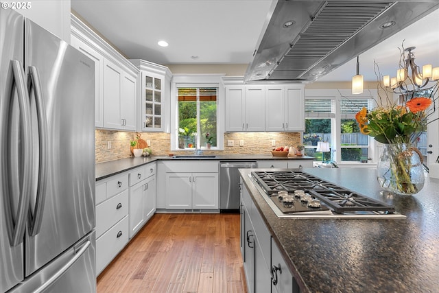 2121 Ostman Rd, West Linn, OR 97068 - kitchen featuring appliances with stainless steel finishes, island exhaust hood, healthy amount of natural light, decorative backsplash, and recessed lighting