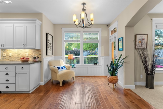 2121 Ostman Rd, West Linn, OR 97068 - sitting room with a chandelier, light wood-style floors, wainscoting, healthy amount of natural light, and a decorative wall