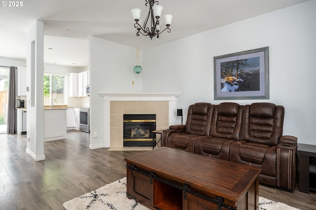 18576 SW Tara Meadows Ct, Beaverton, OR 97078 - living room featuring dark wood-style floors, a fireplace, and a chandelier