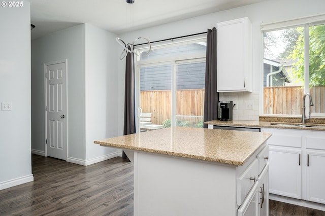 18576 SW Tara Meadows Ct, Beaverton, OR 97078 - kitchen featuring dark wood finished floors, a kitchen island, tasteful backsplash, and white cabinets