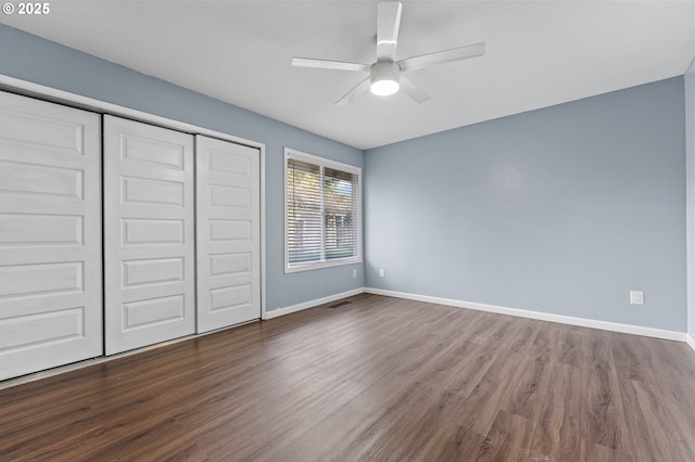 unfurnished bedroom featuring ceiling fan, a closet, and hardwood / wood-style flooring