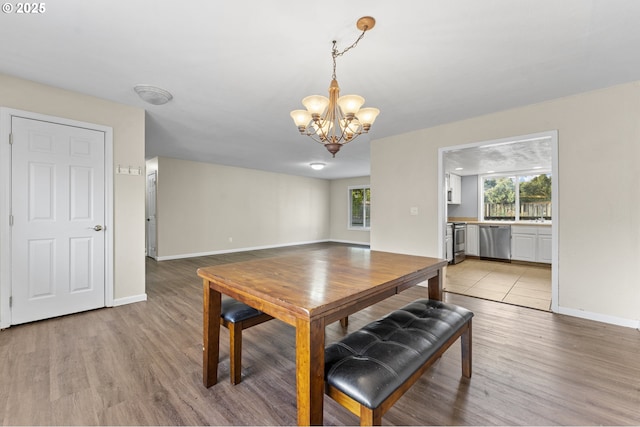 dining room with light wood-type flooring and a notable chandelier