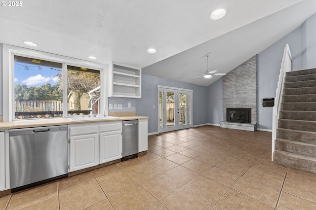 kitchen with dishwasher, lofted ceiling, sink, ceiling fan, and white cabinetry