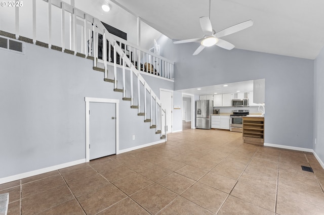 unfurnished living room featuring ceiling fan, light tile patterned flooring, sink, and high vaulted ceiling