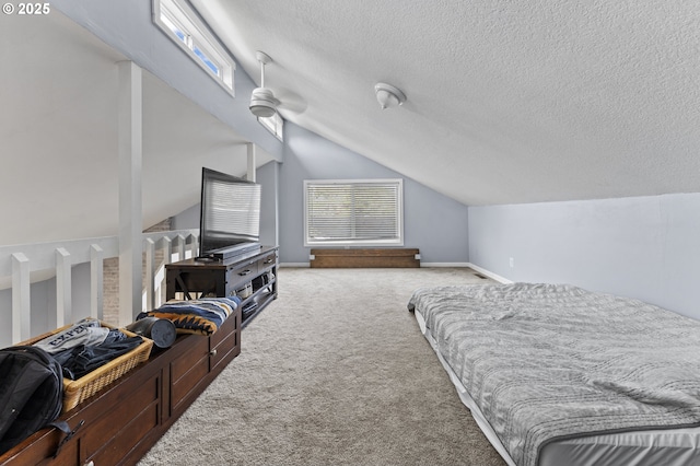 carpeted bedroom with a textured ceiling, vaulted ceiling, and ceiling fan