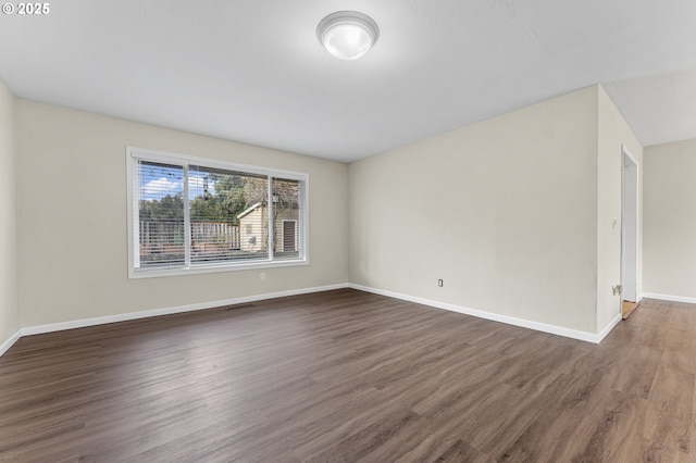 empty room with dark wood-type flooring