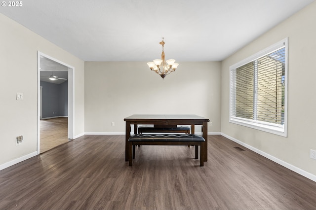 dining space with a wealth of natural light, dark wood-type flooring, and ceiling fan with notable chandelier